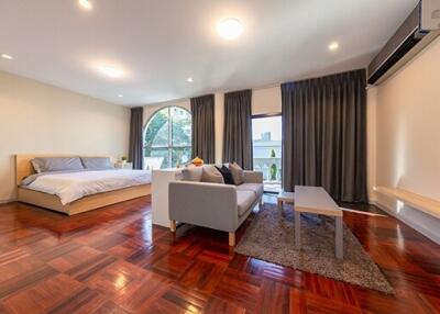Spacious bedroom with a seating area and modern furnishings
