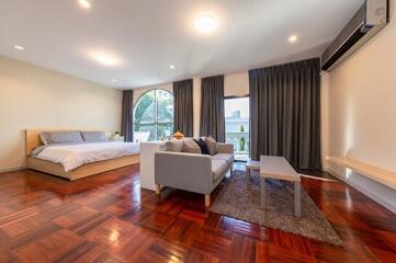 Spacious bedroom with a seating area and modern furnishings
