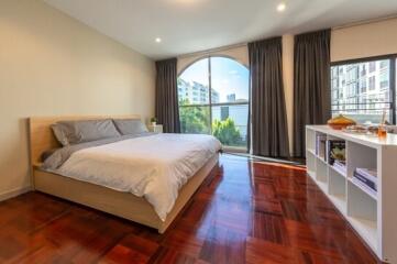 Spacious bedroom with large windows and hardwood floors