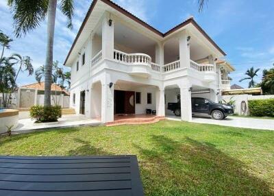 Two-story white house with columns and a driveway