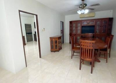 Dining room with wooden table and chairs, ceiling fan, and china cabinet