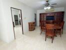 Dining room with wooden table and chairs, ceiling fan, and china cabinet