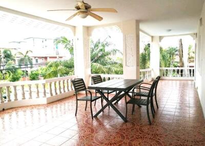 Covered balcony with tile flooring and outdoor furniture