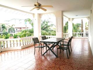 Covered balcony with tile flooring and outdoor furniture