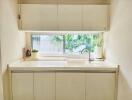 Minimalist white kitchen with large window