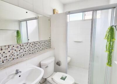 Modern bathroom with white fixtures and a glass shower door