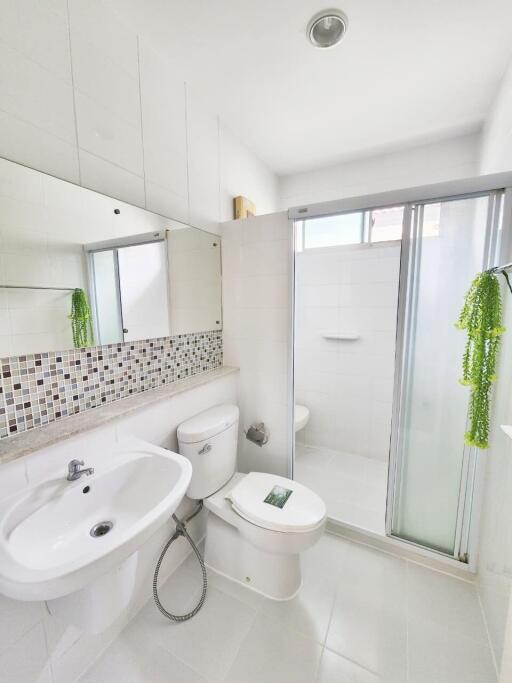 Modern bathroom with white fixtures and a glass shower door