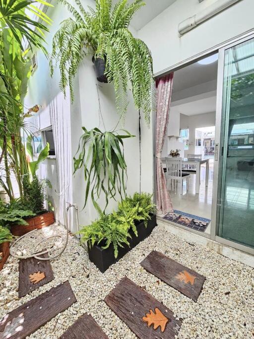 Plant-covered balcony connecting to an indoor space through sliding glass doors