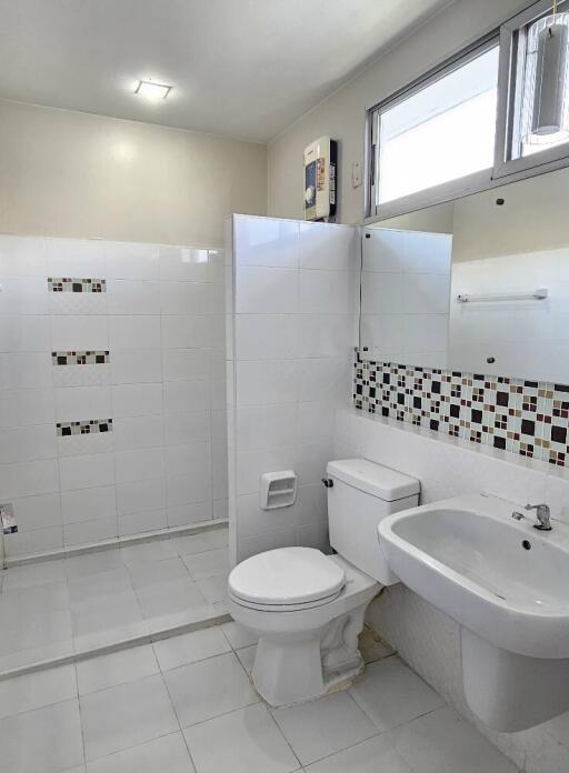 Modern bathroom with shower area, toilet, and sink