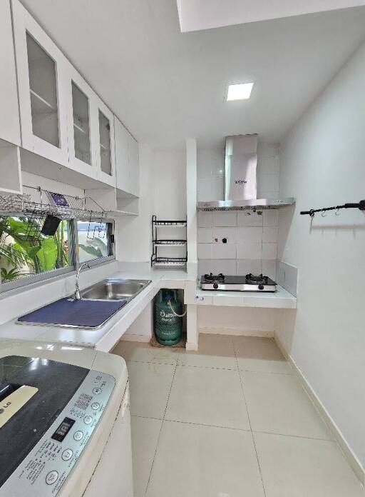 Modern compact kitchen with white cabinetry and stainless steel appliances