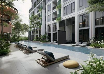 Outdoor pool area with lounge chairs in a modern residential complex