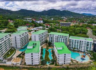 Aerial view of residential buildings with green roofs and a community pool