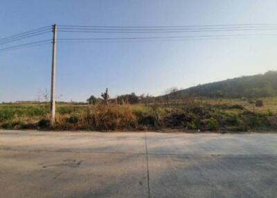 Vacant land with a road and hill in the background