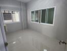 empty room with tiled floor and large windows