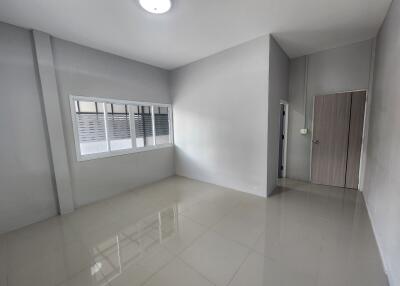 Empty bedroom with white walls and tiled floor