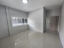 Empty bedroom with white walls and tiled floor