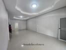 empty room with white walls, tiled floor, and ceiling lights