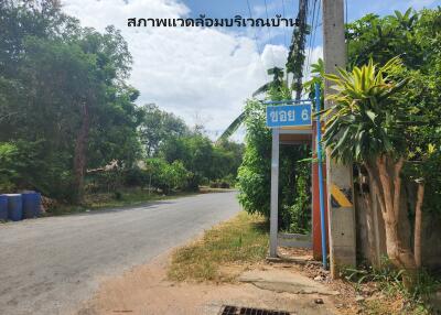 A street view near the property entrance with greenery and a signpost