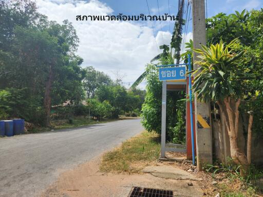 A street view near the property entrance with greenery and a signpost