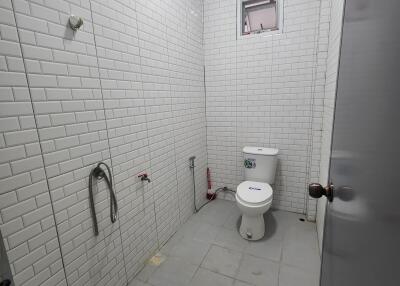 Bathroom with white tiled walls and a toilet