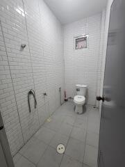 Bathroom with white tiled walls and a toilet