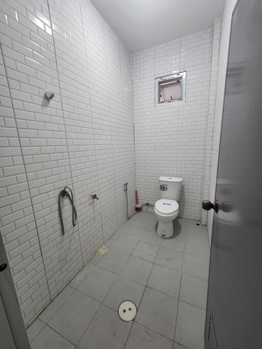 Bathroom with white tiled walls and a toilet