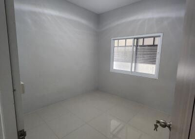 Bedroom with white tile flooring and a window