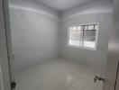 Bedroom with white tile flooring and a window