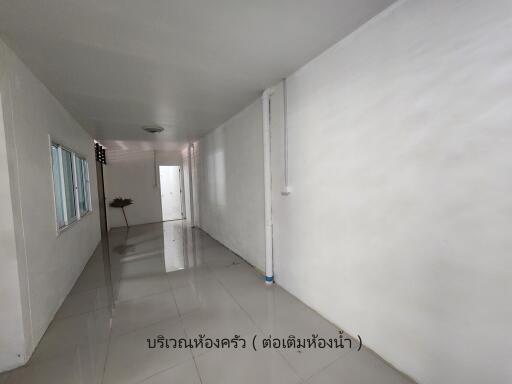 Narrow corridor with white walls and tiled floor