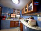 Small kitchen with blue tiles, wooden cabinets and various appliances