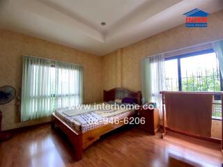 Bedroom with large windows and wooden furniture