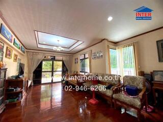 Spacious living room with wooden flooring and framed paintings