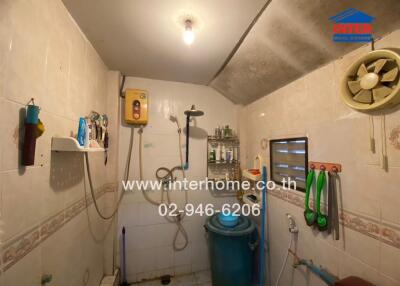 Bathroom with water heater, ventilation fan, and various toiletries