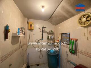 Bathroom with water heater, ventilation fan, and various toiletries