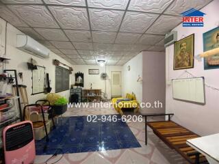 Spacious living room with ceiling fan, sofa and framed photos on wall