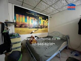 Simple bedroom with a metal bed frame and a wall poster