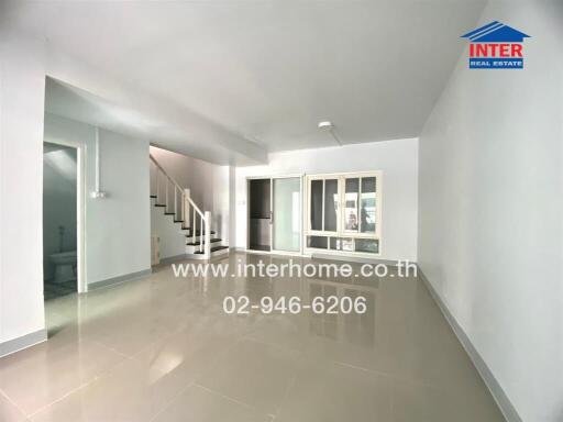 Spacious main living area with large tiles and staircase