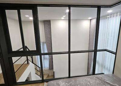 Modern bedroom with glass partition overlooking a stairway