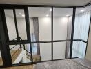 Modern bedroom with glass partition overlooking a stairway