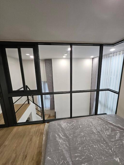 Modern bedroom with glass partition overlooking a stairway