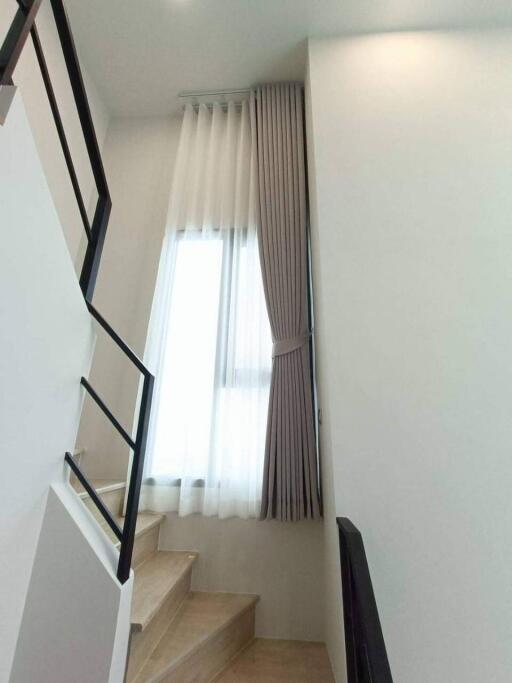 Modern staircase with white walls and large window