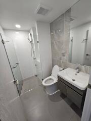 Modern bathroom with glass shower, toilet, and vanity sink