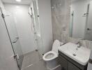 Modern bathroom with glass shower, toilet, and vanity sink