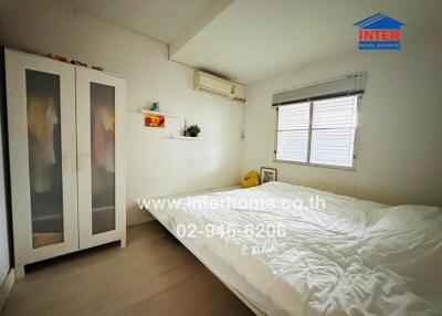 Cozy bedroom with a double bed, white wardrobe, air conditioning, and window with blinds