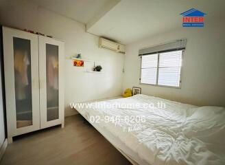 Cozy bedroom with a double bed, white wardrobe, air conditioning, and window with blinds