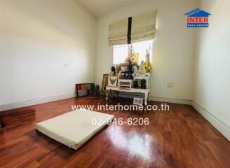 Minimalist bedroom with hardwood floor and shrine