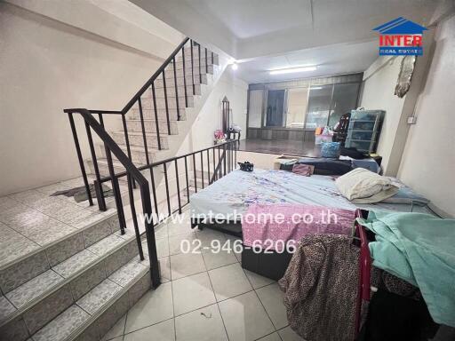 Bedroom with bed, stairs, and window