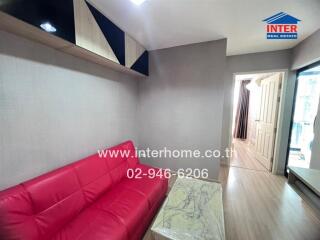 Living area with red sofa and wall-mounted shelves