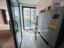 Modern kitchenette with a view to the bedroom and balcony