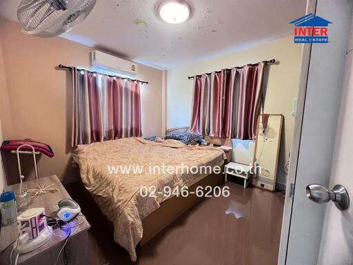 Bedroom with bed, curtains, and air conditioning unit